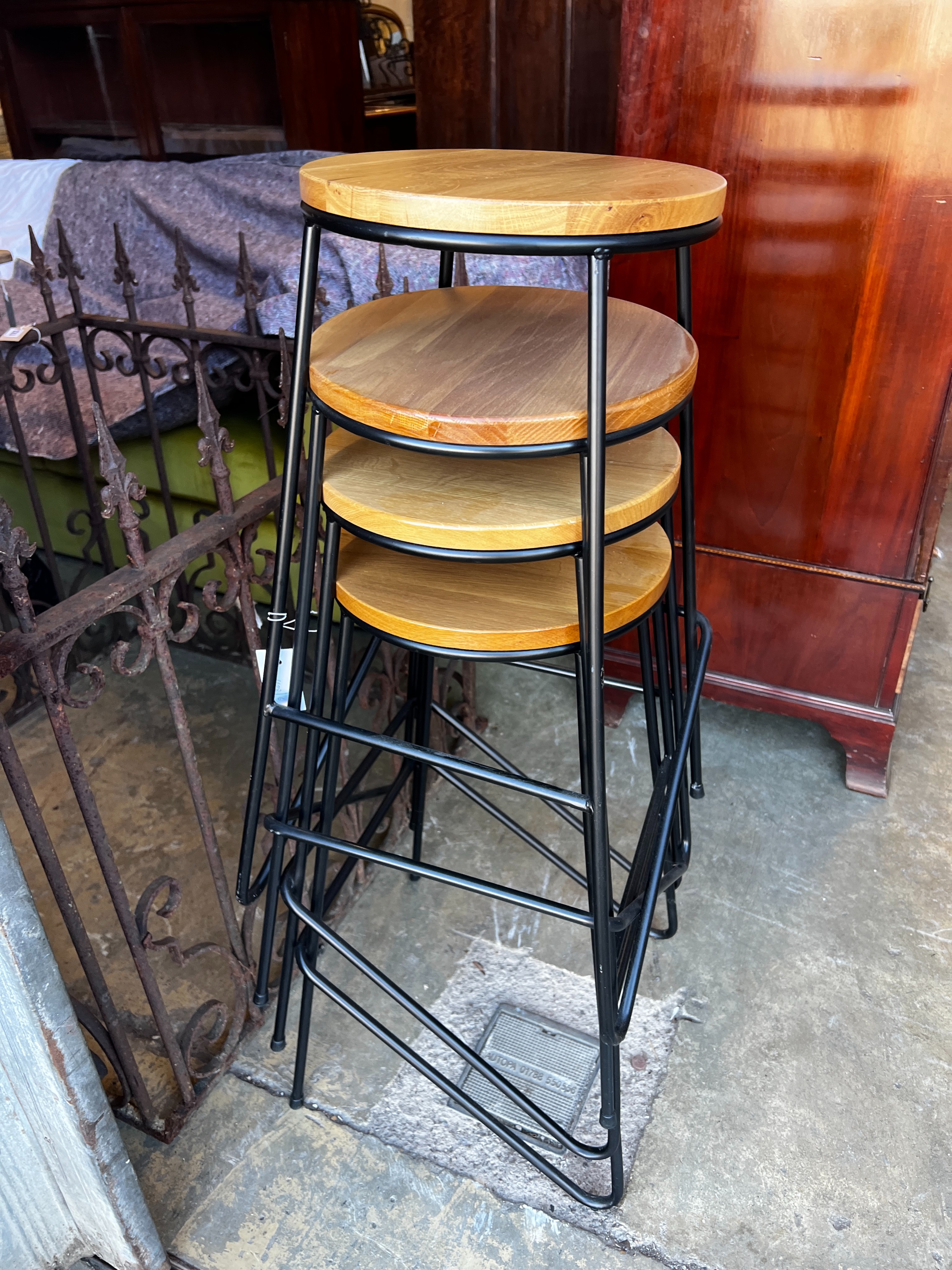 A set of four industrial style wrought iron and oak bar stools, height 70cm